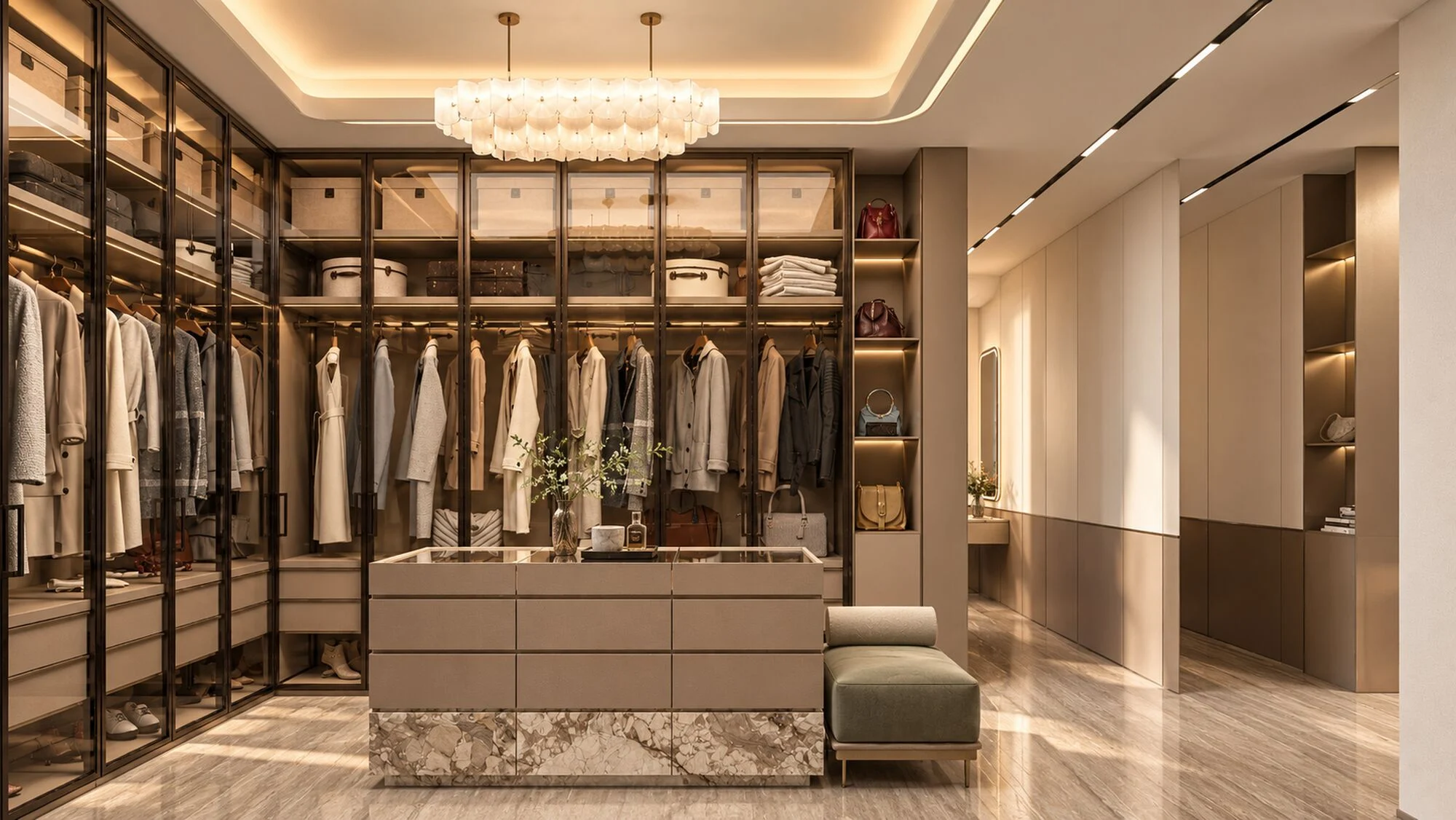 Walk-in closet with bronze-framed glass wardrobes, a stone-clad island and a sage bench in a Hatta villa by Tohfa