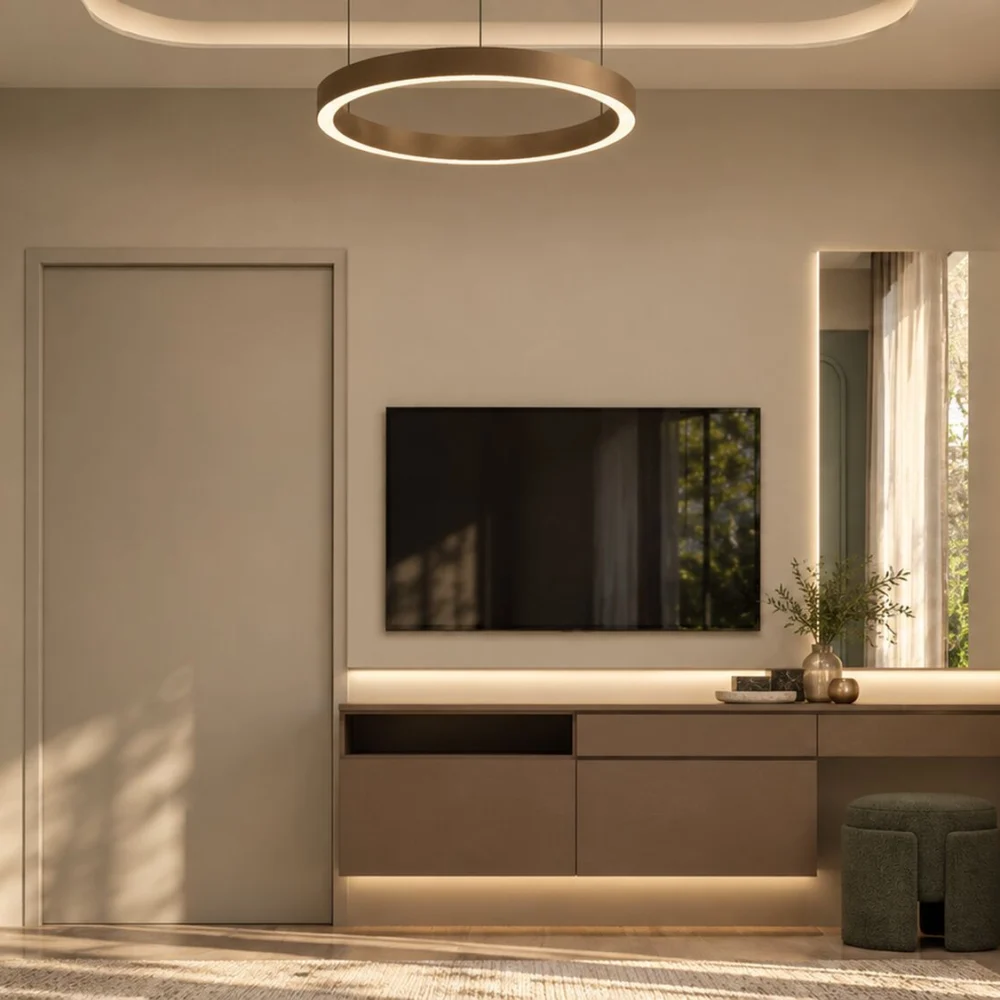 Bedroom television console continuing into a dressing counter with a lit mirror and a green pouf