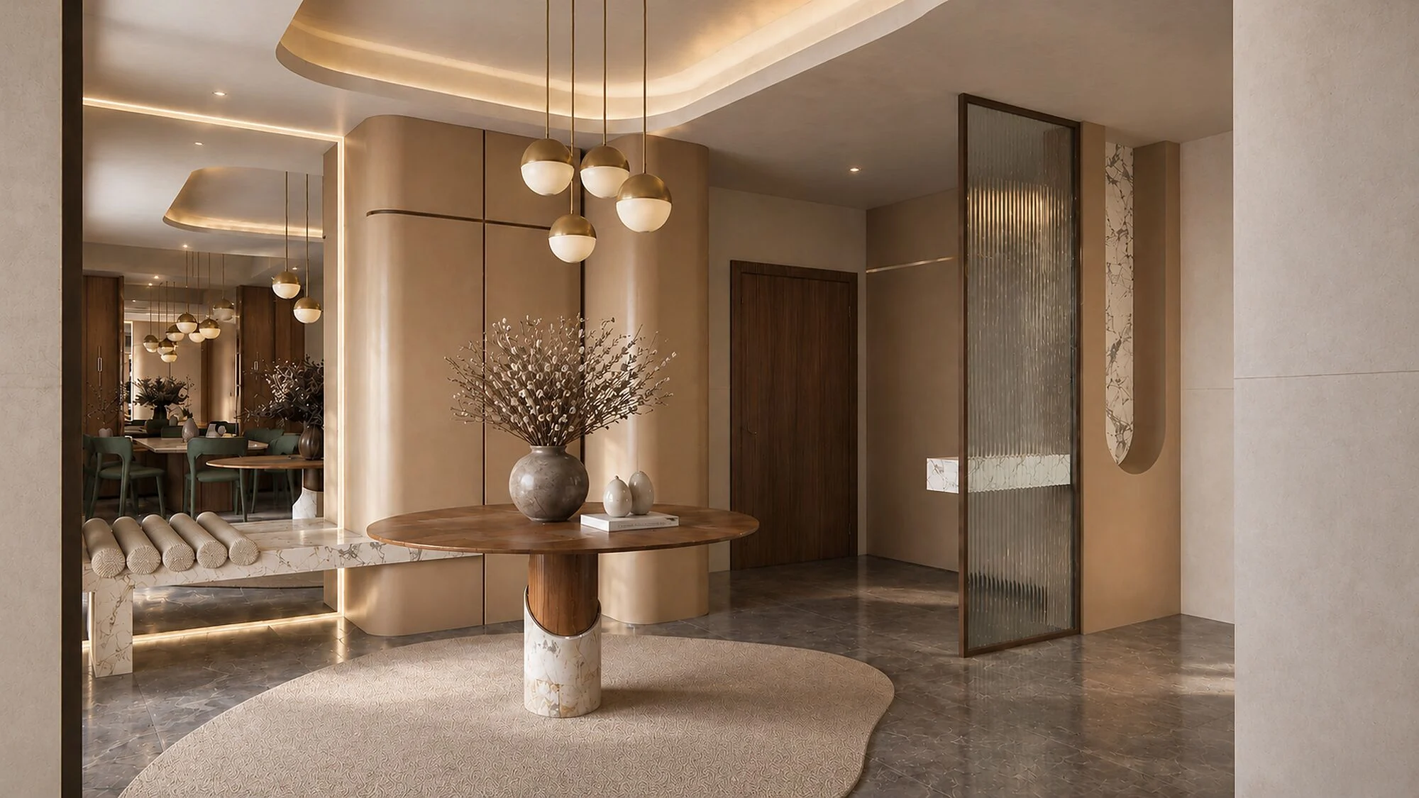 Entrance lobby with a round walnut and stone table, brass pendants and a fluted glass screen in a Sharjah Sustainable City townhouse by Tohfa